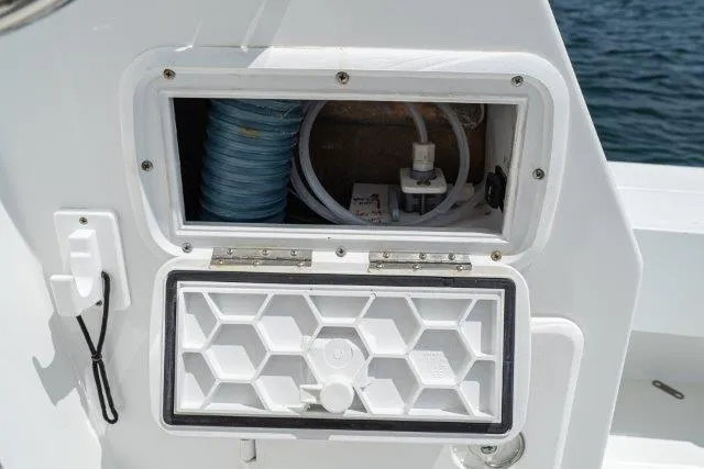 Slide: The Image of Open compartment on a 2011 Skipjack 300 Flybridge boat, showing internal wiring and components. - 43