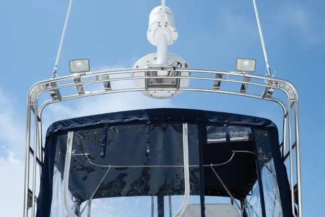 Slide: The Image of Skipjack 300 Flybridge 2011 boat with radar and lights against blue sky. - 45