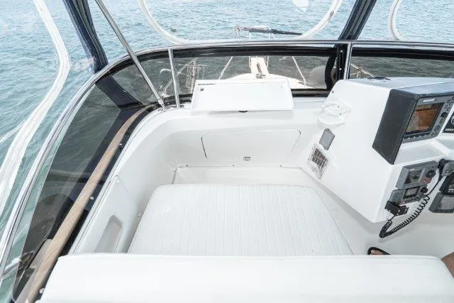 Slide: The Image of Flybridge of 2011 Skipjack 300, featuring navigation controls and seating, overlooking the ocean. - 53