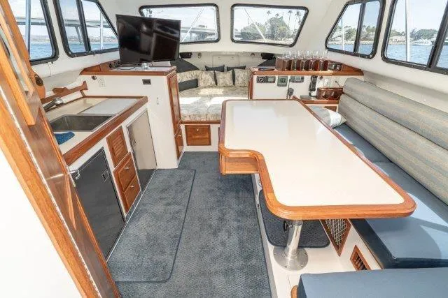 Slide: The Image of Interior of 2011 Skipjack 300 Flybridge boat with seating, table, and kitchenette. - 57