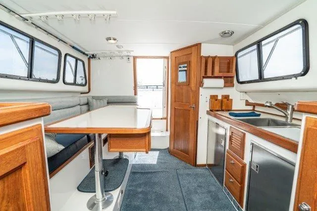 Slide: The Image of Interior of 2011 Skipjack 300 Flybridge with kitchen and dining area. - 58