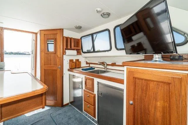 Slide: The Image of Interior of 2011 Skipjack 300 Flybridge with wood cabinetry and modern appliances. - 59