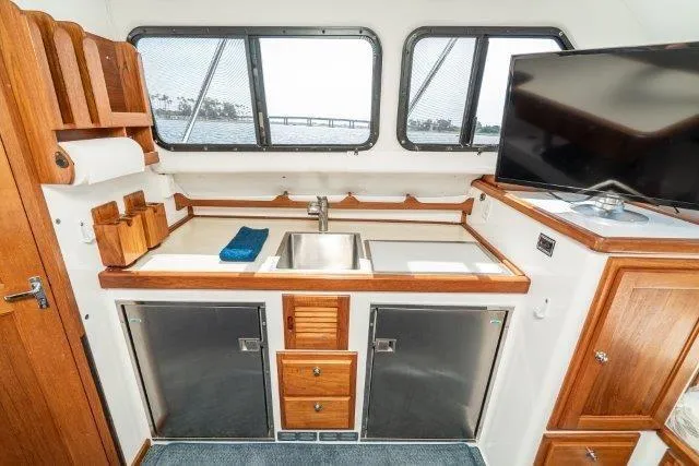 Slide: The Image of Interior of 2011 Skipjack 300 Flybridge boat with kitchenette and TV. - 60