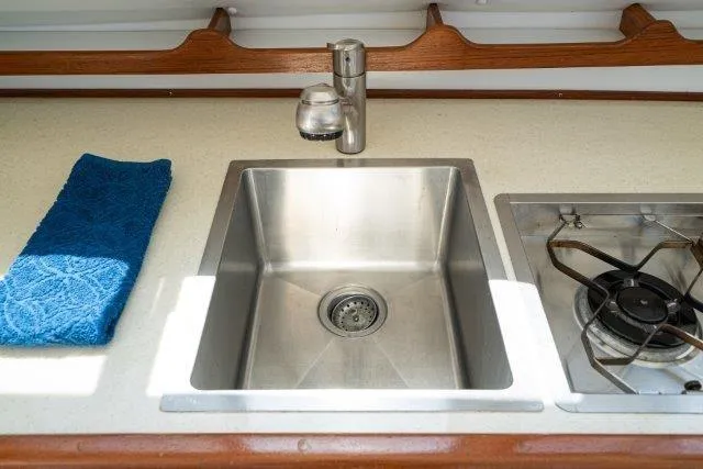 Slide: The Image of Stainless steel sink and stove in 2011 Skipjack 300 Flybridge boat kitchen. - 63