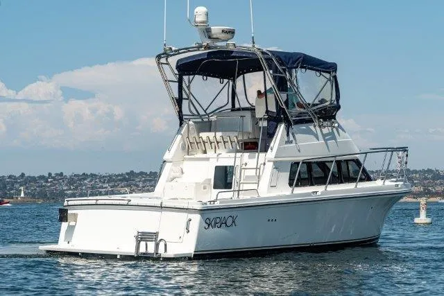 Slide: The Image of 2011 Skipjack 300 Flybridge boat on water, featuring a sleek design and spacious flybridge. - 7