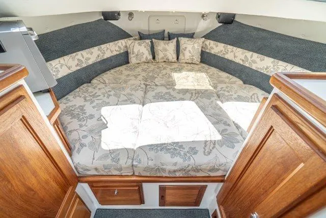 Slide: The Image of Cozy cabin interior of 2011 Skipjack 300 Flybridge with floral bedding and wooden cabinetry. - 72
