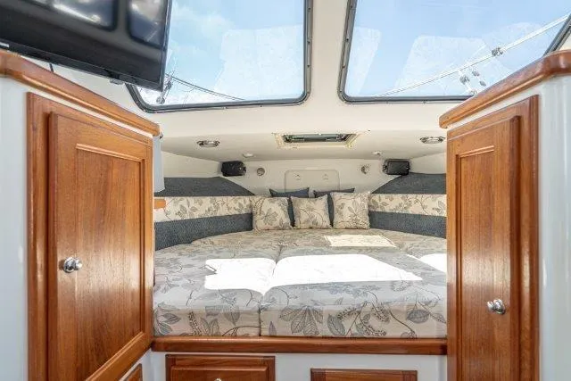 Slide: The Image of Cozy cabin interior of 2011 Skipjack 300 Flybridge with floral bedding and wooden cabinets. - 73