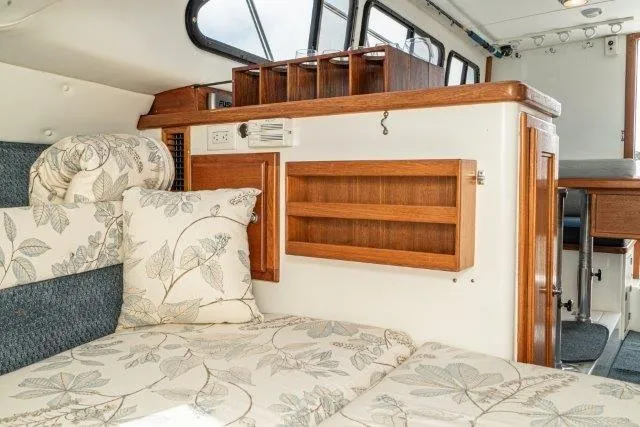 Slide: The Image of Interior of 2011 Skipjack 300 Flybridge with floral cushions and wooden cabinetry. - 75