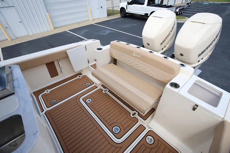 Slide: The Image of 2022 Scout 330 LXF boat interior with dual Mercury engines and teak flooring. - 13
