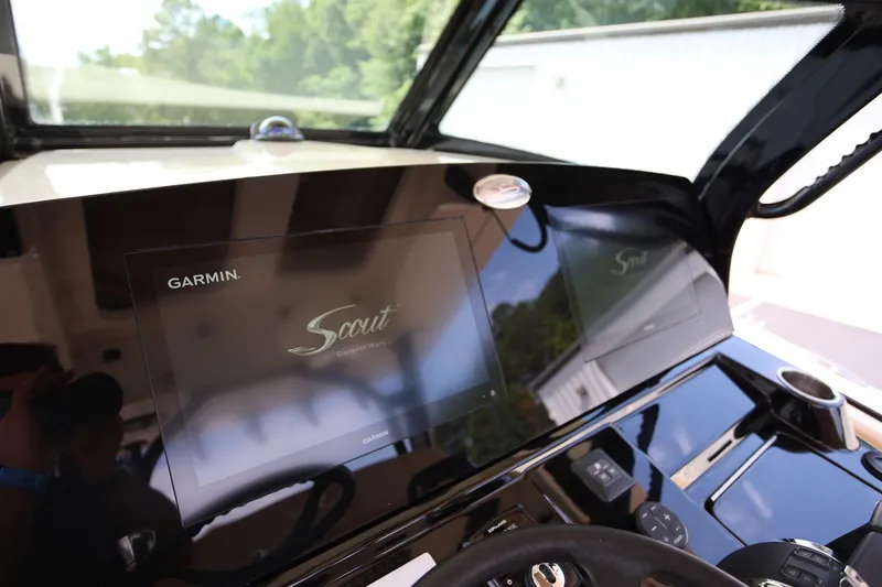Slide: The Image of 2022 Scout 330 LXF boat dashboard featuring Garmin display and sleek black finish. - 16