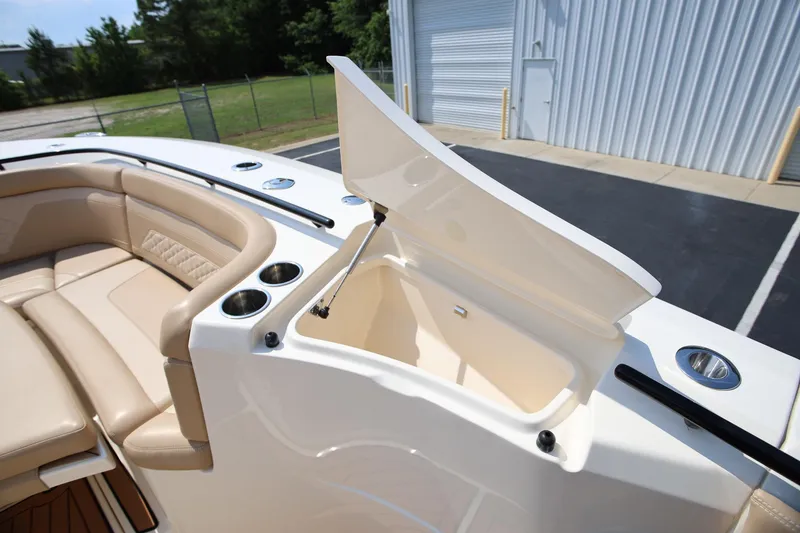 Slide: The Image of 2022 Scout 330 LXF boat interior with open storage compartment and beige seating. - 29