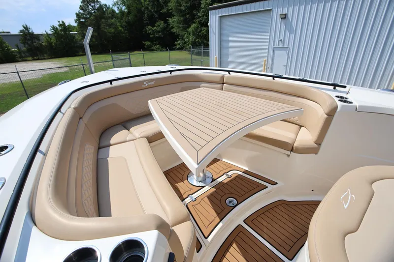 Slide: The Image of 2022 Scout 330 LXF boat interior with beige seating and wooden table. - 31