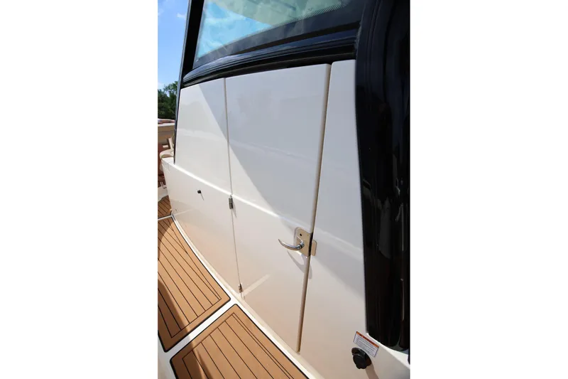 Slide: The Image of 2022 Scout 330 LXF boat exterior with sleek white finish and teak flooring. - 33