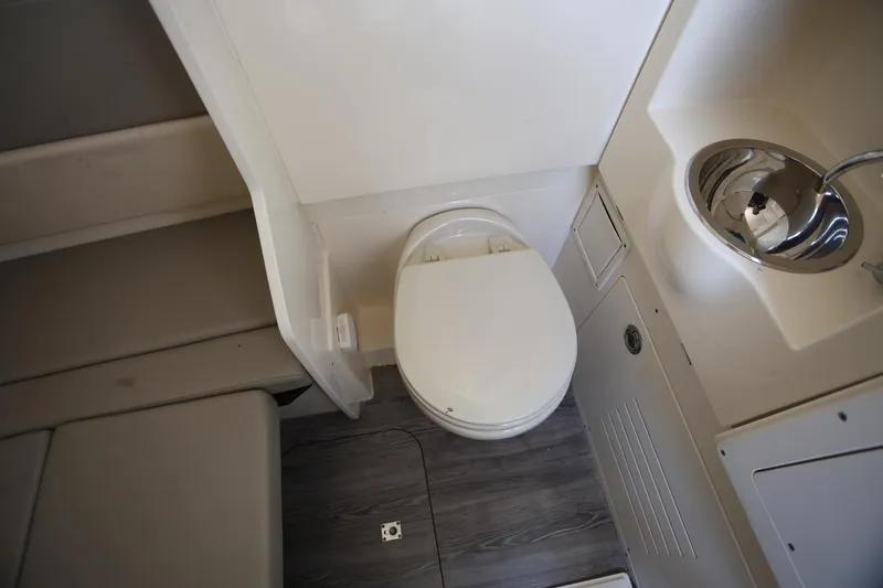 Slide: The Image of 2022 Scout 330 LXF boat interior with toilet and sink in compact bathroom. - 37