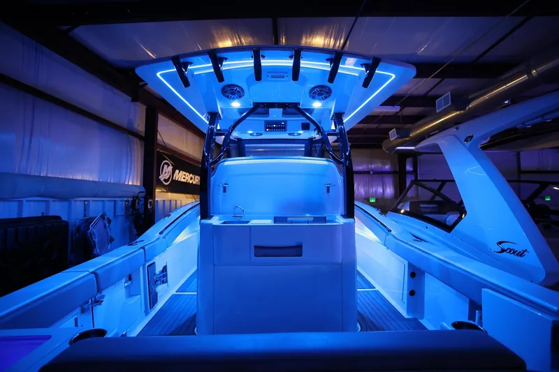 Slide: The Image of 2022 Scout 330 LXF boat interior with blue LED lighting in a showroom. - 38
