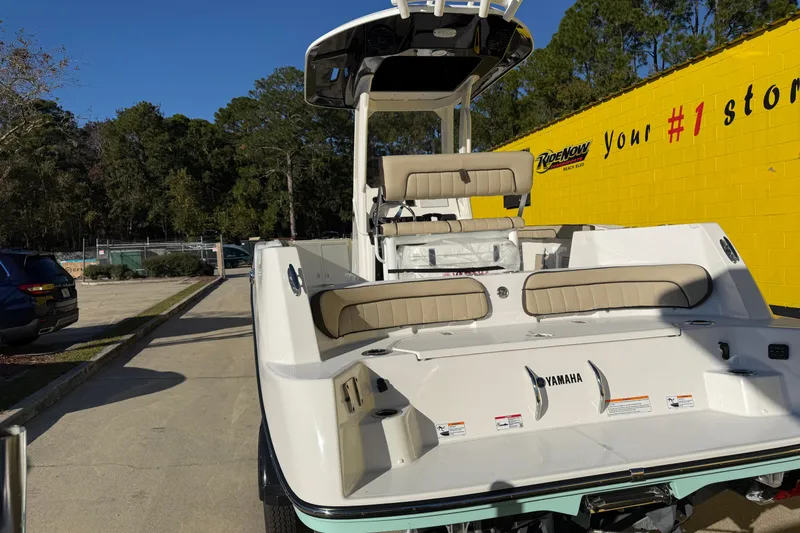 Slide: The Image of 2026 Yamaha Boats 222 FSH Sport E, parked outdoors, showcasing sleek design and seating. - 11