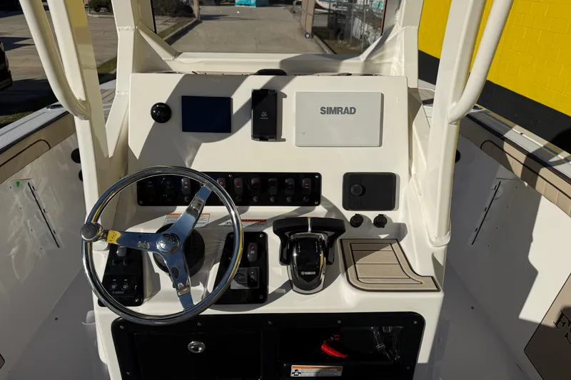 Slide: The Image of 2026 Yamaha Boats 222 FSH Sport E dashboard with steering wheel and Simrad display. - 14