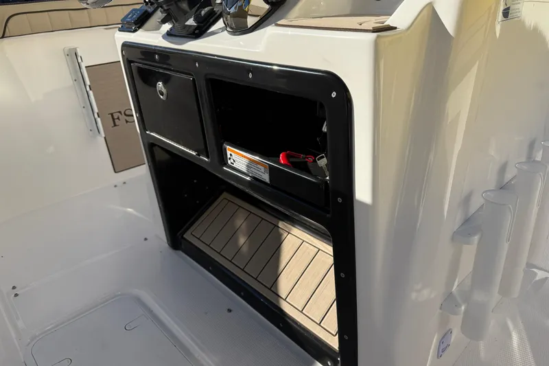 Slide: The Image of 2026 Yamaha Boats 222 FSH Sport E console storage with open compartments and accessories. - 16