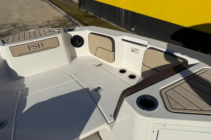 Slide: The Image of 2026 Yamaha Boats 222 FSH Sport E interior with seating and cup holders. - 23
