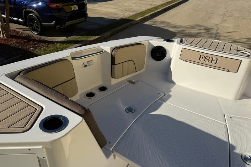 Slide: The Image of Interior view of 2026 Yamaha Boats 222 FSH Sport E, featuring seating and cup holders. - 24