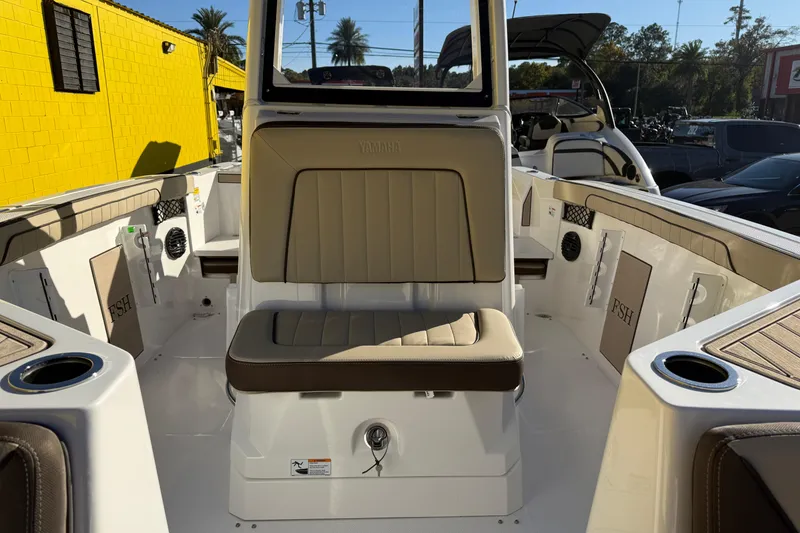 Slide: The Image of 2026 Yamaha Boats 222 FSH Sport E interior with beige seating and cup holders. - 25