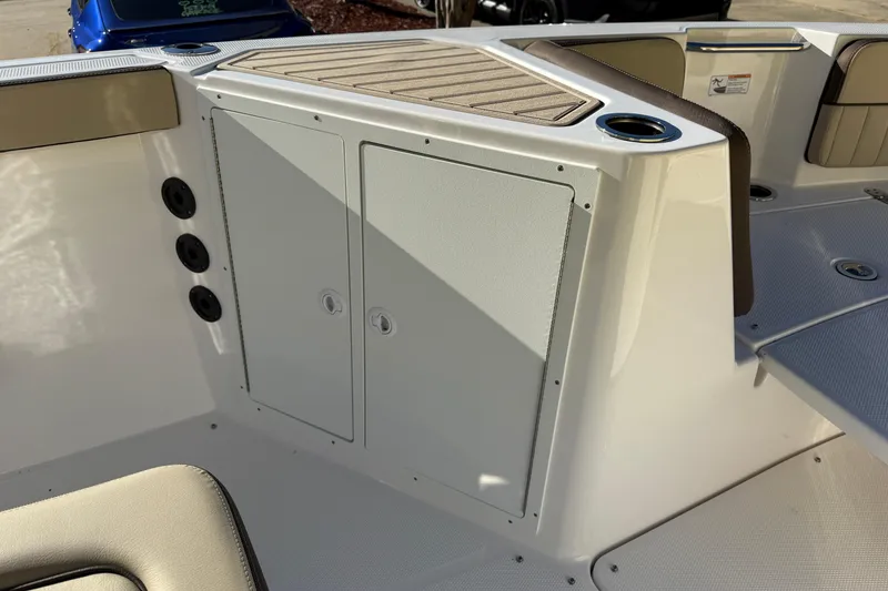 Slide: The Image of 2026 Yamaha Boats 222 FSH Sport E interior storage compartment with cup holders and seating. - 28