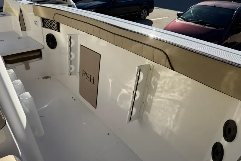 Slide: The Image of Interior view of 2026 Yamaha Boats 222 FSH Sport E, featuring rod holders and storage. - 34