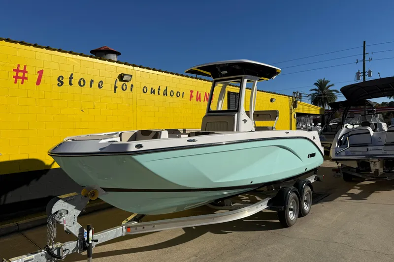 Slide: The Image of 2026 Yamaha Boats 222 FSH Sport E on trailer, parked outside a yellow building. - 4