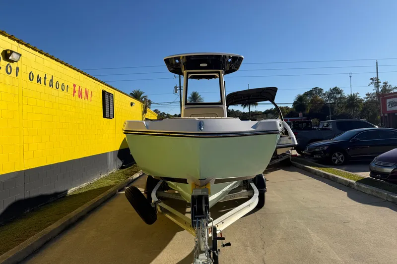 Slide: The Image of 2026 Yamaha Boats 222 FSH Sport E on trailer, parked outdoors near a yellow building. - 5