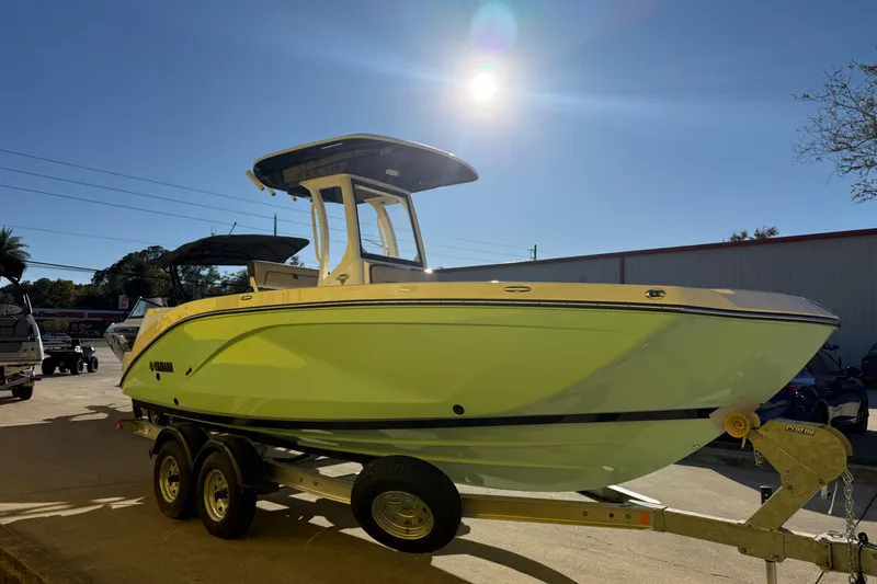 Slide: The Image of 2026 Yamaha Boats 222 FSH Sport E on trailer under bright sun. - 7