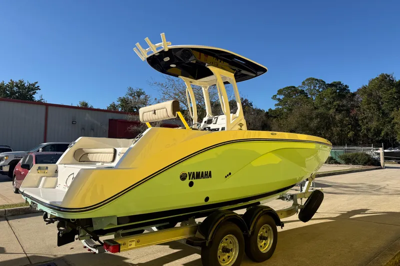 Slide: The Image of 2026 Yamaha Boats 222 FSH Sport E in vibrant yellow on trailer, sunny day. - 8