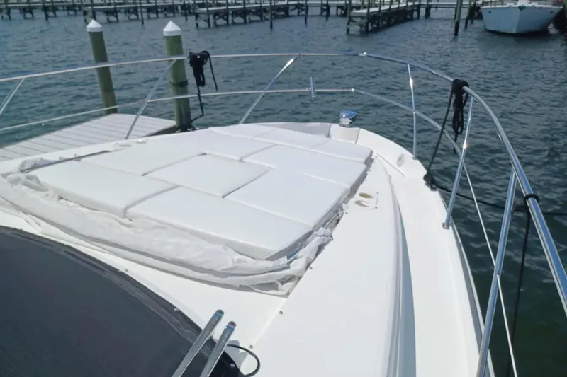 Slide: The Image of 2023 Regal 42 FXO yacht bow with sunpad, docked at marina. - 7