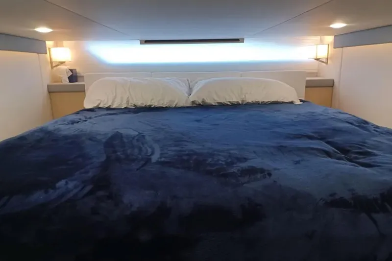 Slide: The Image of Luxurious bedroom interior of 2023 Regal 42 FXO yacht with plush bedding and ambient lighting. - 25