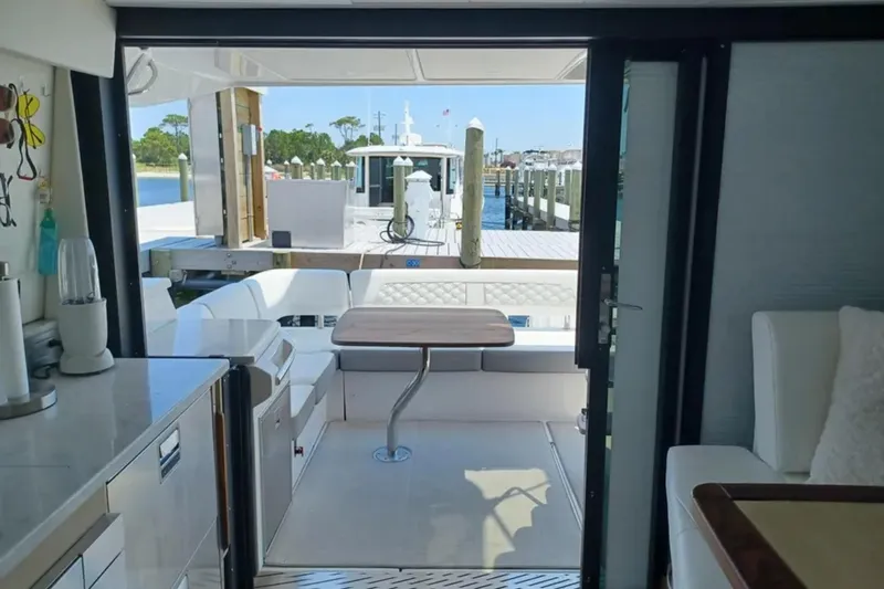 Slide: The Image of Interior view of 2023 Regal 42 FXO yacht, featuring elegant seating and a dockside view. - 13