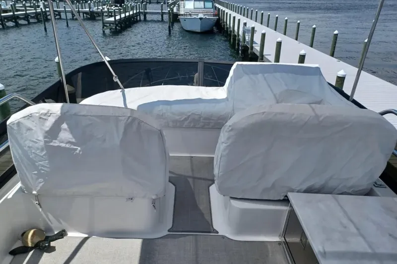 Slide: The Image of 2023 Regal 42 FXO yacht with covered seating, docked at a marina. - 16