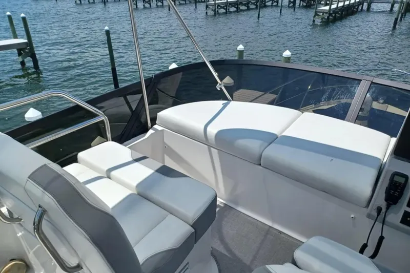 Slide: The Image of 2023 Regal 42 FXO boat interior with white seating, overlooking a serene waterfront. - 15