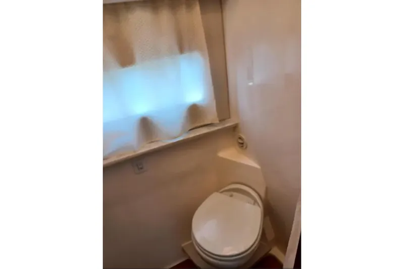 Slide: The Image of Bathroom interior of 2023 Regal 42 FXO yacht with window and toilet. - 28