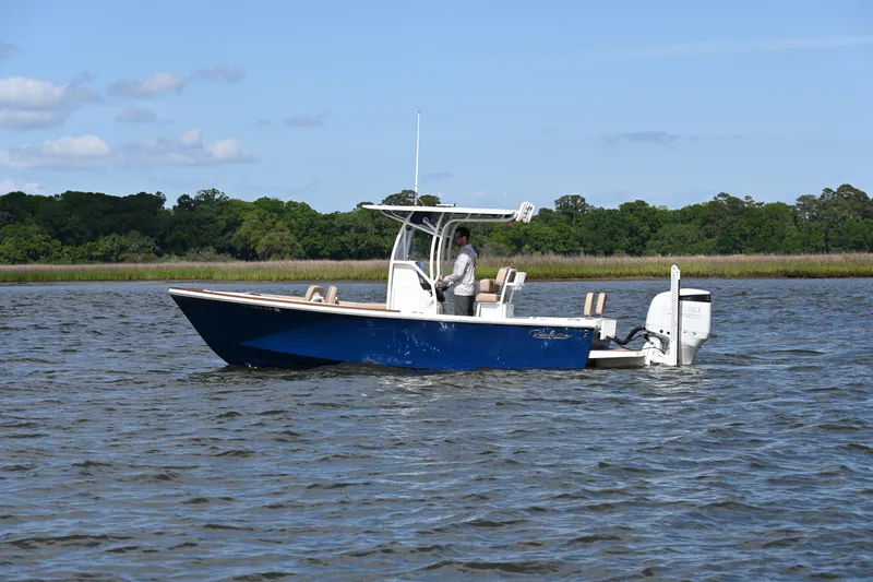 Slide: The Image of 2022 Pair Customs 21 Center Console DV boat cruising on a scenic waterway. - 1