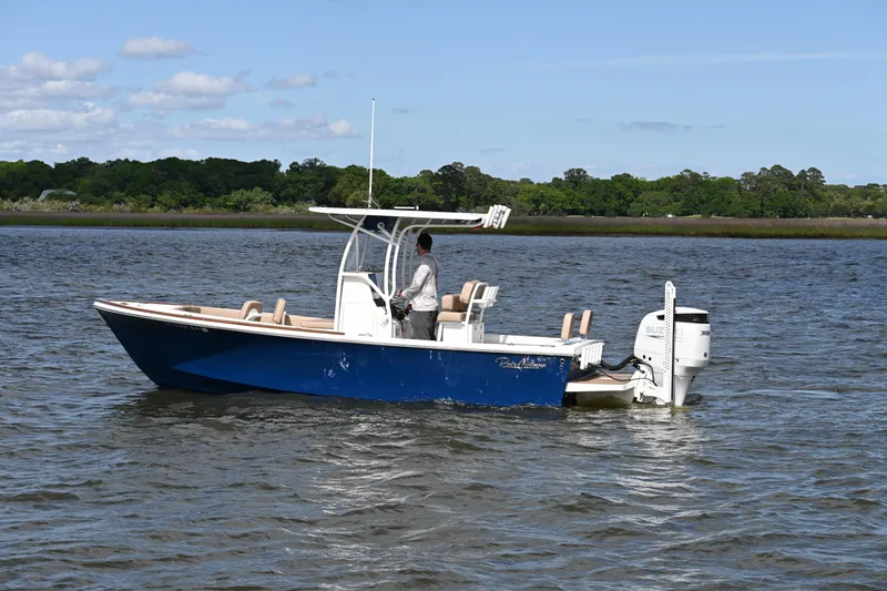 Slide: The Image of 2022 Pair Customs 21 Center Console DV boat on water, featuring a sleek blue design. - 2