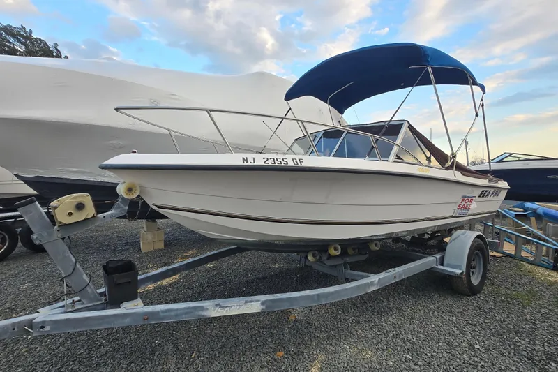 The Image of 1994 Sea Pro 190 Dual Console boat on trailer, for sale, with blue canopy. - 0
