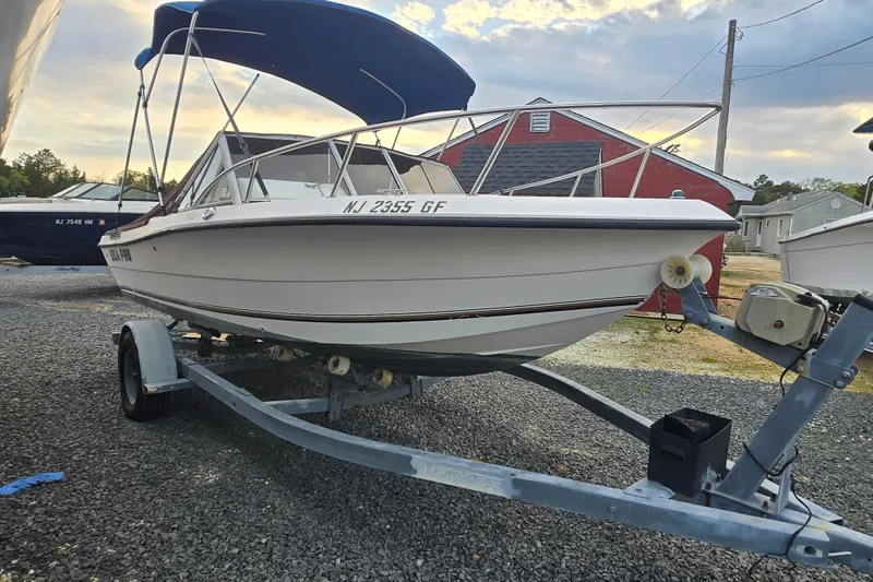 Slide: The Image of 1994 Sea Pro 190 Dual Console boat on trailer with blue canopy, parked outdoors. - 5