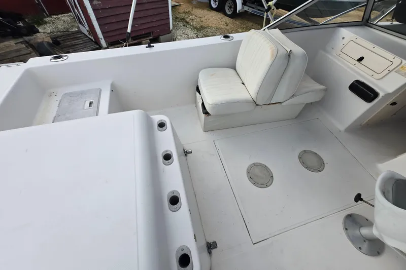 Slide: The Image of 1994 Sea Pro 190 Dual Console boat interior with white seating and storage compartments. - 9