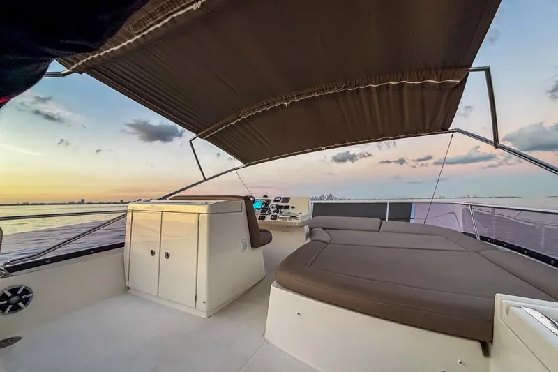 Slide: The Image of 2013 Prestige 500 yacht deck at sunset, featuring comfortable seating and canopy. - 6