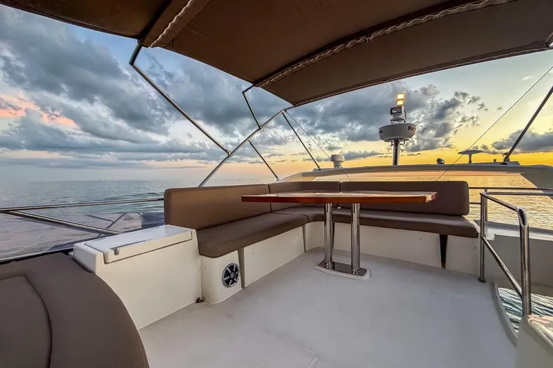 Slide: The Image of Flybridge seating area on 2013 Prestige 500 yacht at sunset over the ocean. - 7