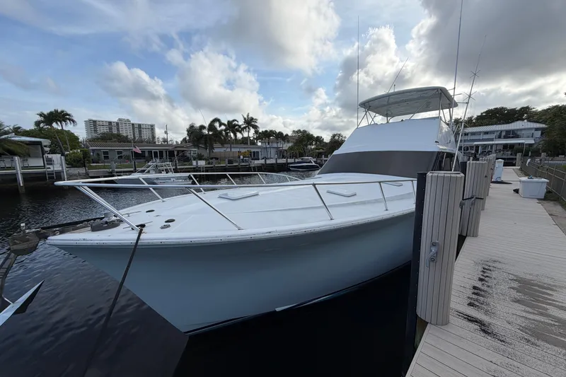 The Image of 1985 Ocean Yachts 55 Super Sport docked at a marina under a cloudy sky. - 0