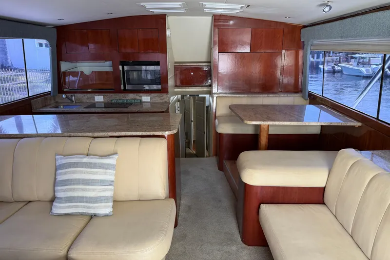 Slide: The Image of Interior of 1985 Ocean Yachts 55 Super Sport with beige seating and wooden cabinetry. - 12
