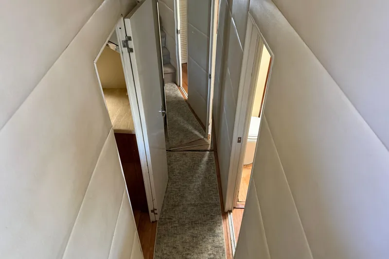 Slide: The Image of Narrow hallway inside 1985 Ocean Yachts 55 Super Sport, featuring doors and carpeted floor. - 15
