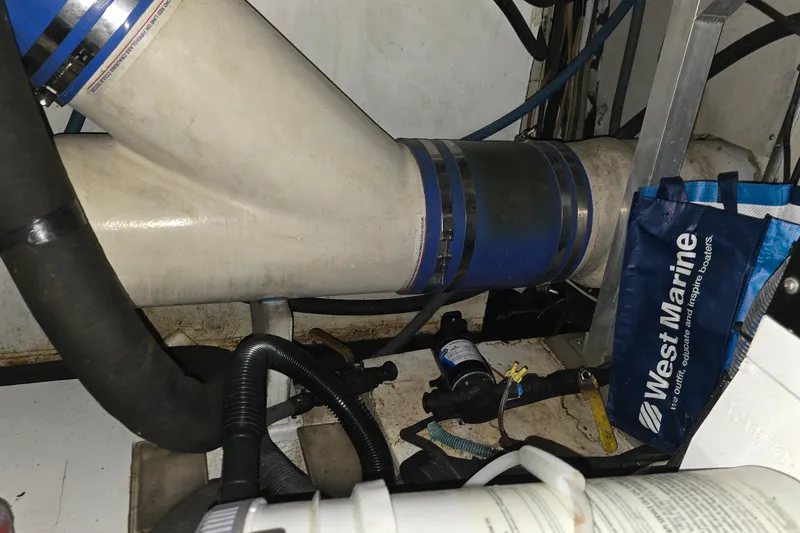 Slide: The Image of Engine room of 1985 Ocean Yachts 55 Super Sport with marine equipment and hoses. - 25