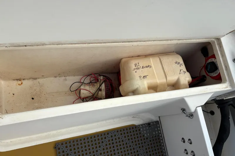 Slide: The Image of Storage compartment of a 1979 Mako Pro Skiff 21 CC with battery and wiring. - 11