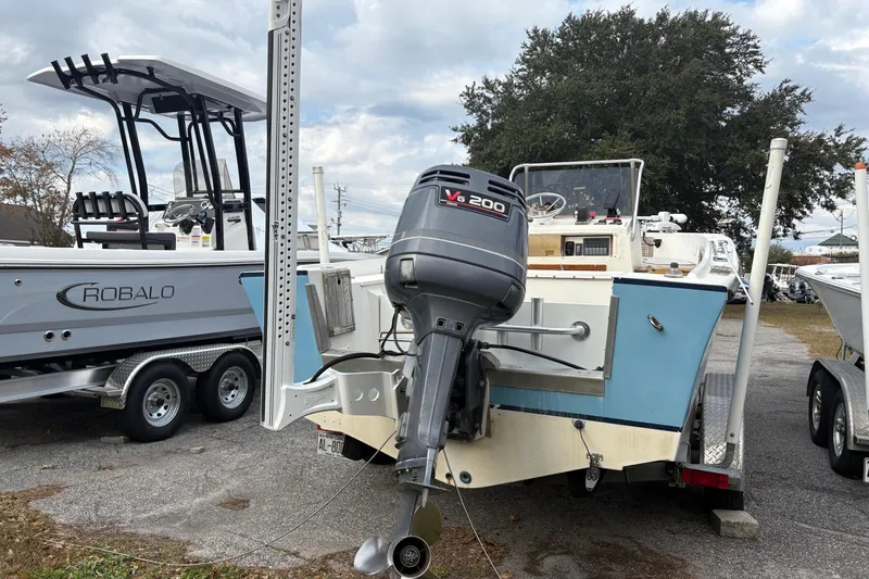 Slide: The Image of 1979 Mako Pro Skiff 21 CC with V6 200 outboard motor, parked beside Robalo boat. - 3
